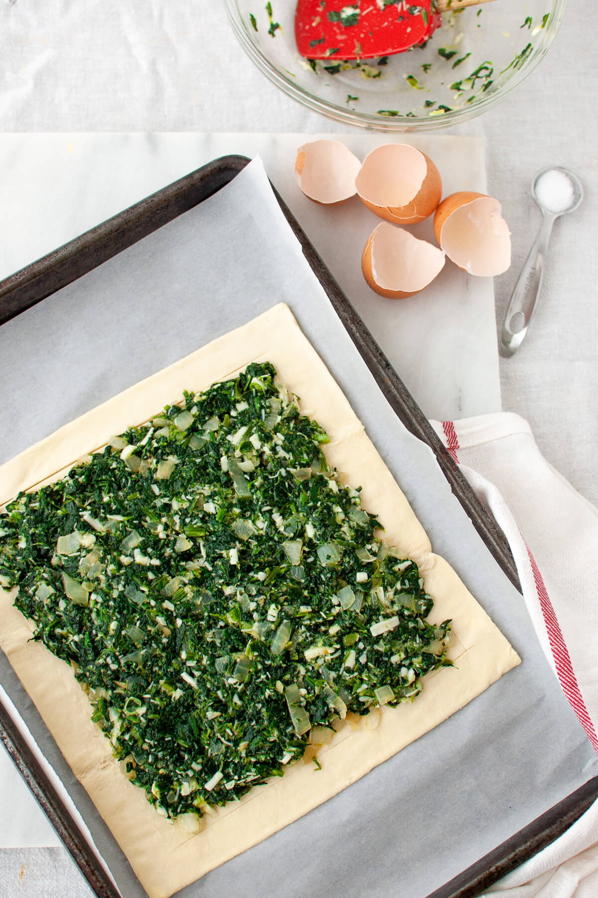 A spinach tart on a baking tray ready to be baked.