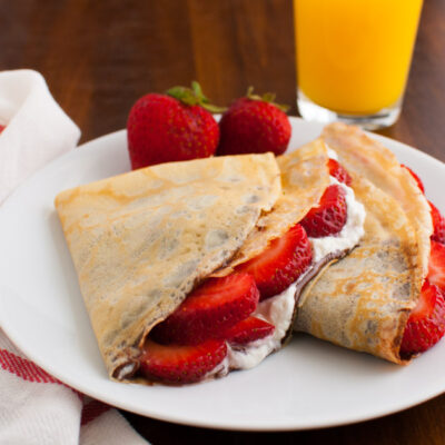 Crêpes filled with strawberries, whipped cream, and nutellas.