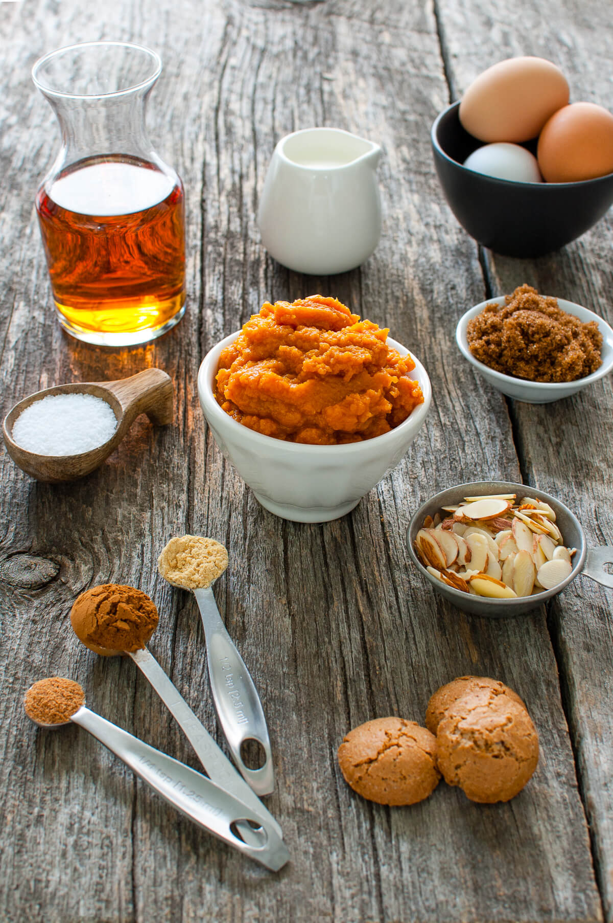 Ingredients for making pumpkin streusel pie on a wooden tabletop.