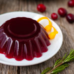 Molded cranberry jelly on a white plate.