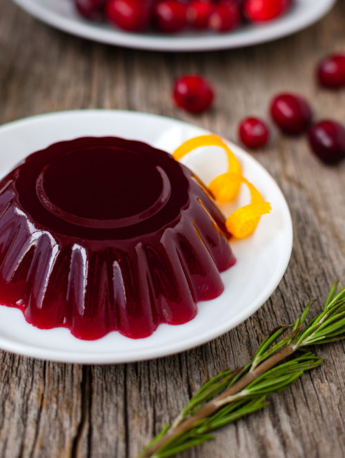 Molded cranberry jelly on a white plate.