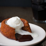 Chocolate cake with melted chocolate on the inside and topped with whipped cream.