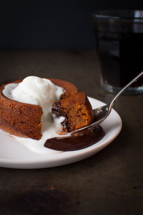 A spoon cutting into a piece of molten chocolate cake.