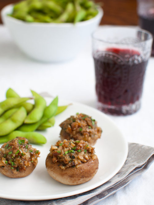 Mushrooms stuffed with cheddar cheese, walnuts, and onions served with some edamame and red wine.