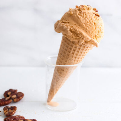 A scoop of dulce de leche ice-cream on a sugar cone.