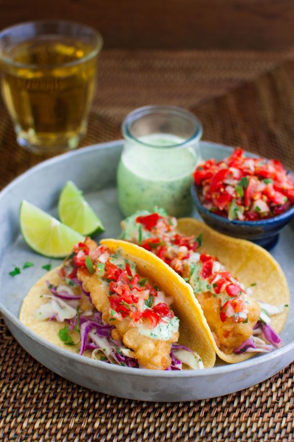 Fish tacos on a metal serving tray.