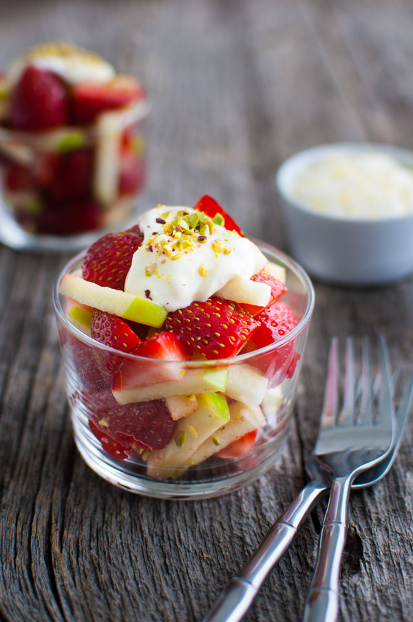 Strawberry and apple salad in a glass cup.