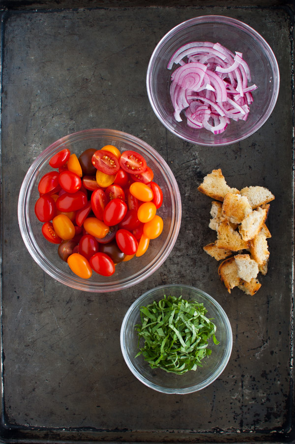 Sliced onions, cut cherry tomatoes, chopped fresh basil, and toasted bread chunks.