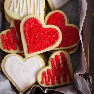Decorated heart shaped sugar cookies in a tissue lined box.