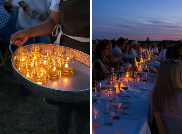 A person holding a tray of tealights. A table lit by tealights.