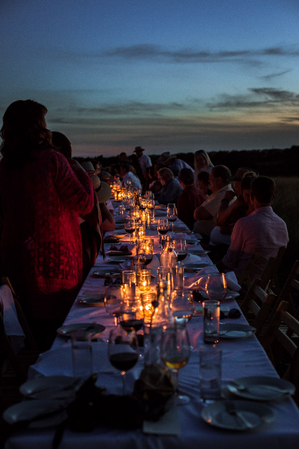 People standing next to a table lit by tealights.