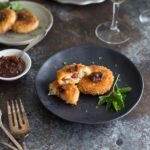 Risotto cakes topped with pesto and served with a glass of wine.