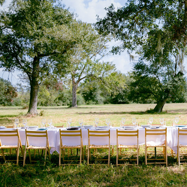 A table set outside near some trees.