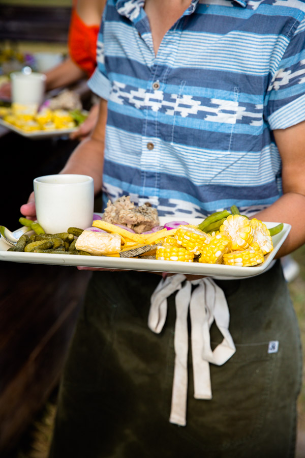 A server holding a platter of vegetables.