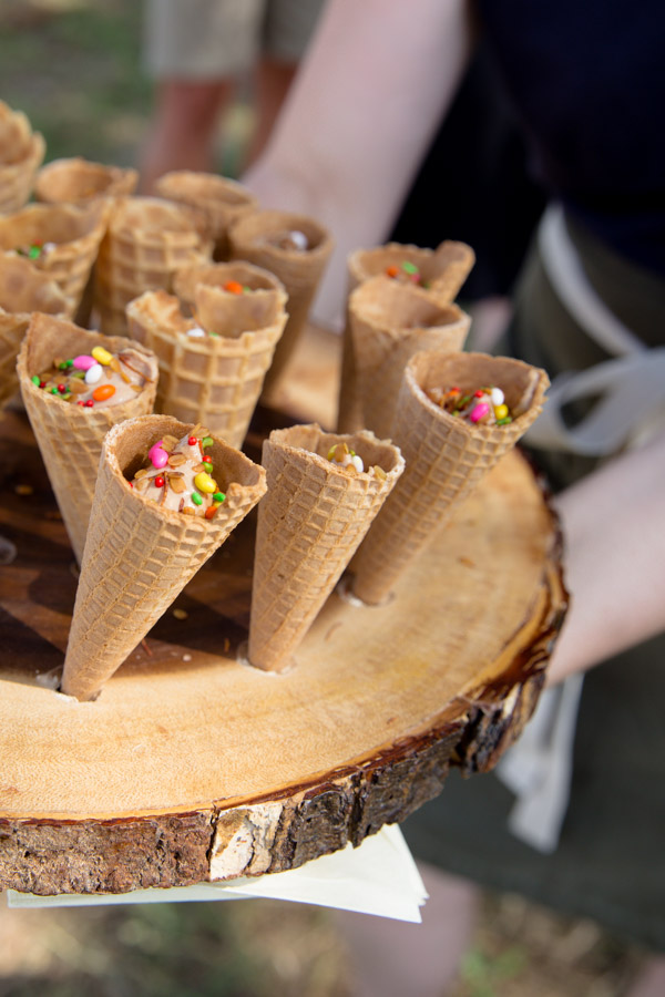 Appetizers being served from a wooden tray.