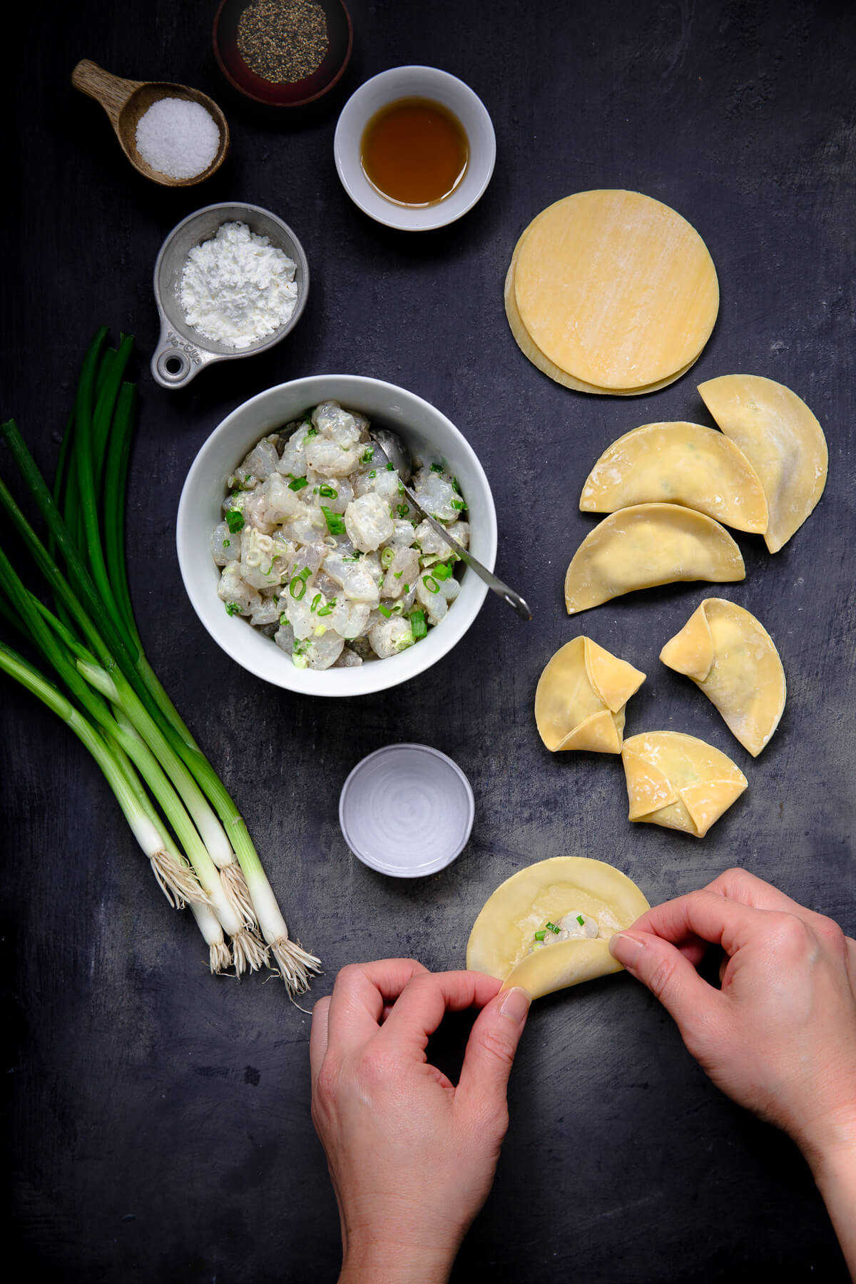 Overhead view showing someone making some shrimp dumplings for soup.