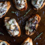 Roasted mushrooms and melted cheese on toasted bread slices.