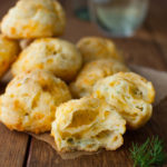 Cheddar dill puffs on a wooden background.