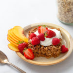 Plate of baked oatmeal topped with yogurt and fresh fruit.