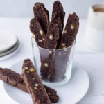 Chocolate-orange biscotti in a glass on a white plate.