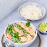 Bowl of salmon in coconut-miso broth with green beans served with a bowl of rice.