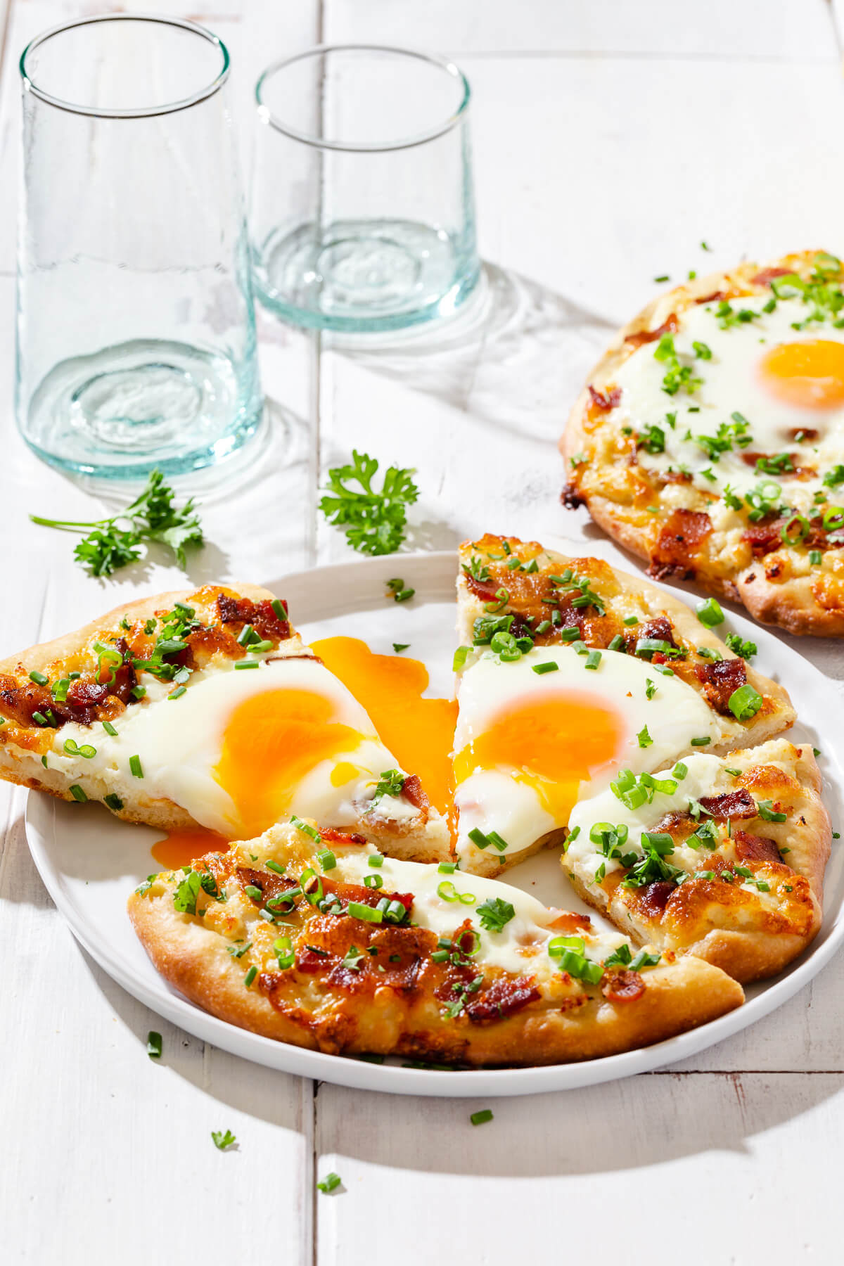 Slices of breakfast pizza on a white plate.