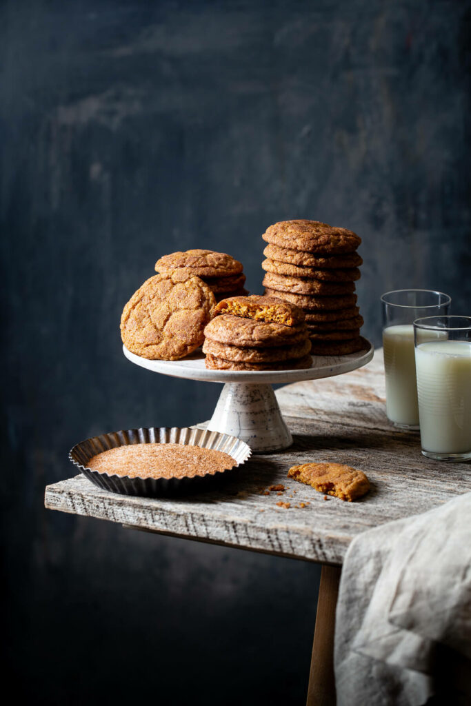 Stacks of pumpkin snickerdoodle cookies on a cake stand.