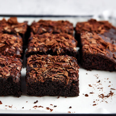 Slices of chocolate sheet cake on a white tray.