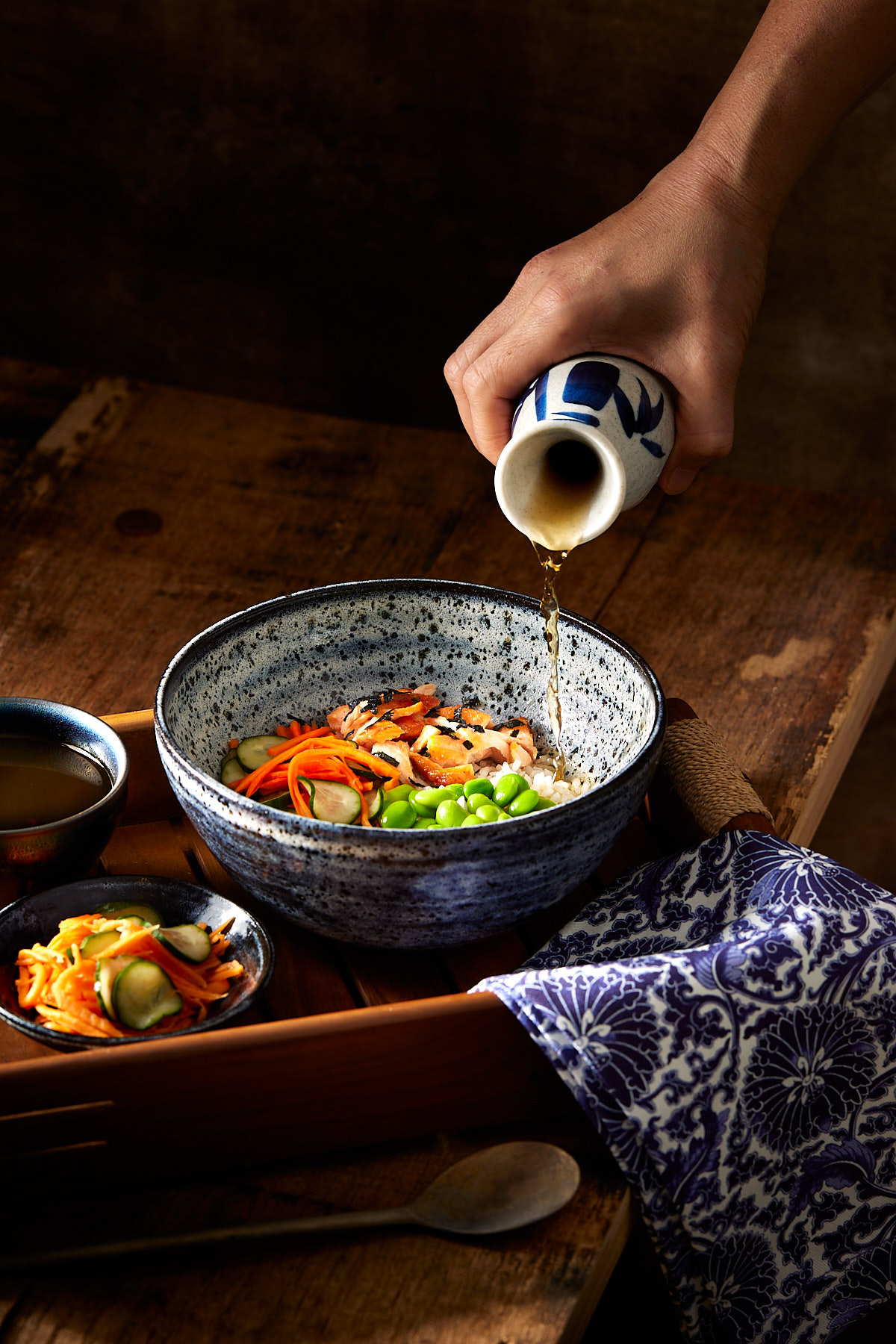 Dashi broth being poured into a bowl of salmon and rice.