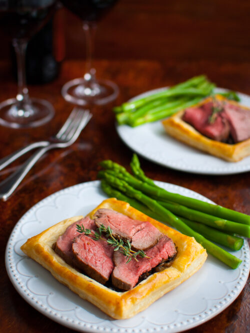 Beef Wellington tarts served with asparagus.