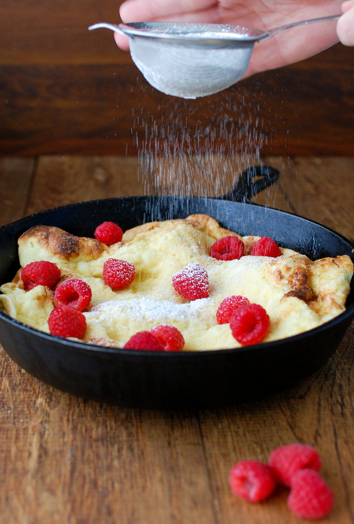 Pear dutch baby sprinkled with powdered sugar.