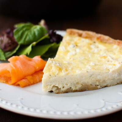 Slice of potato and boursin frittata on a white plate.