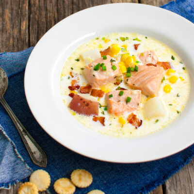 Bowl of salmon chowder served with oyster crackers.