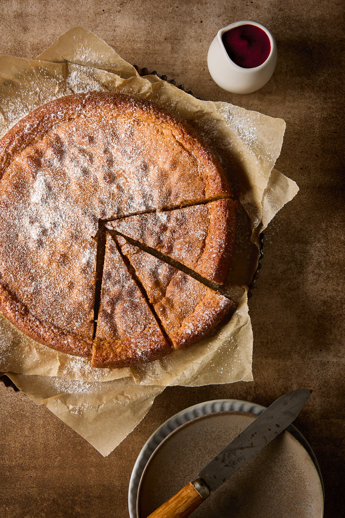 Almond torte with three slices cut.