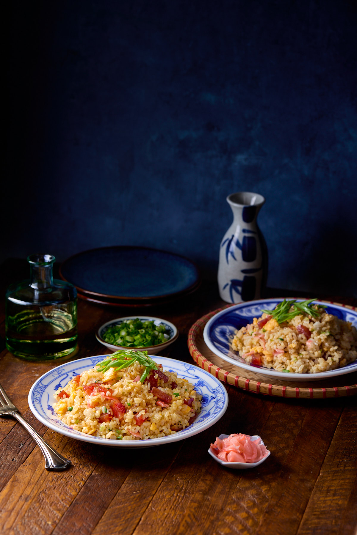 Two plates of fried rice on a wooden table.