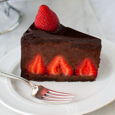 A slice of chocolate strawberry mousse cake on a white plate.