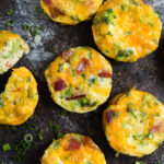 Close-up of mini frittatas on a wooden board.