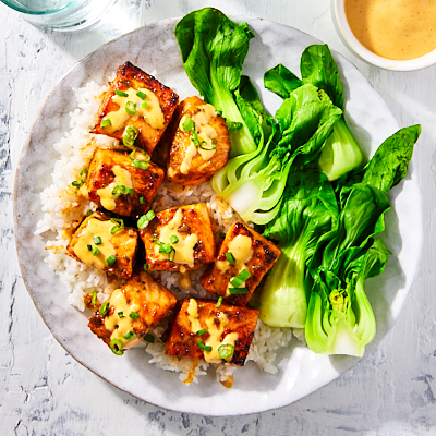 Honey sriracha salmon bites topped with some sriracha mayo sauce and chopped green onions.