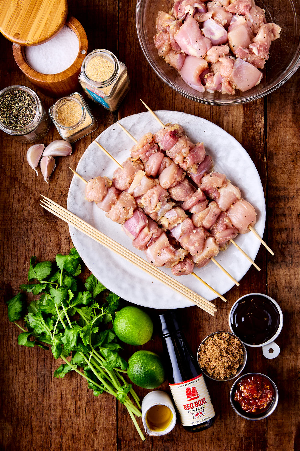 Ingredients for making Asian chicken skewers on a wooden background.