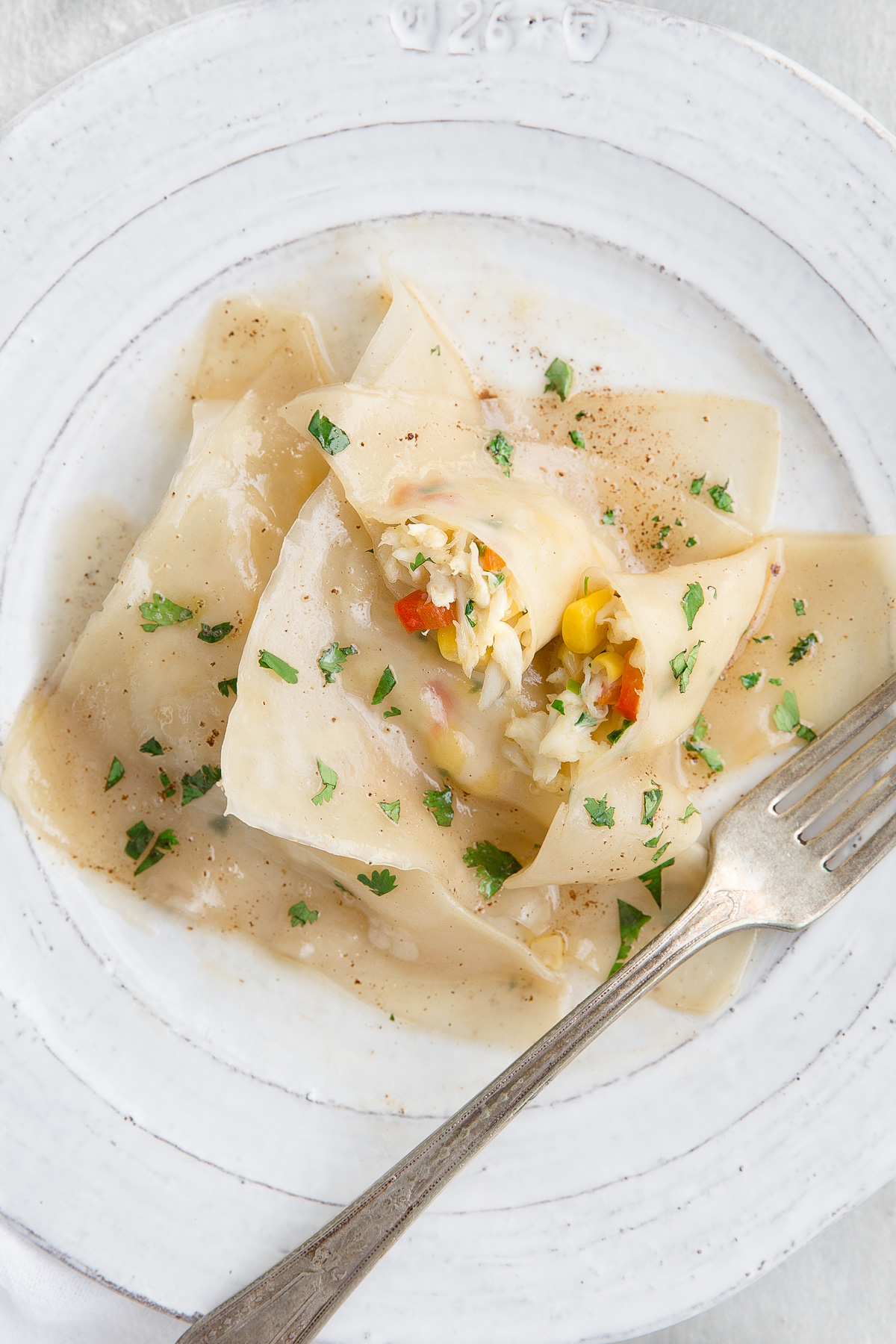 A piece of ravioli showing the crab and corn filling.