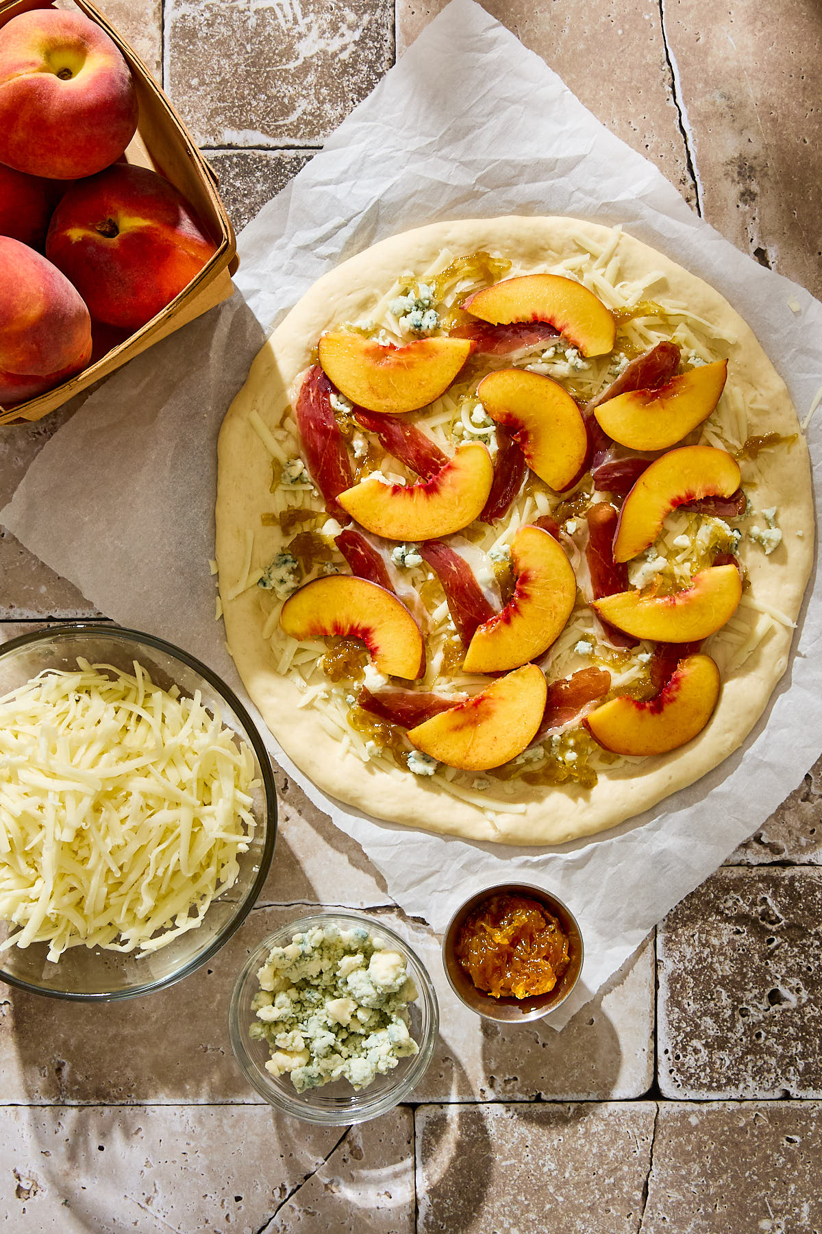 Pizza dough topped with peach slices, duck prosciutto, caramelized onions, and blue cheese.