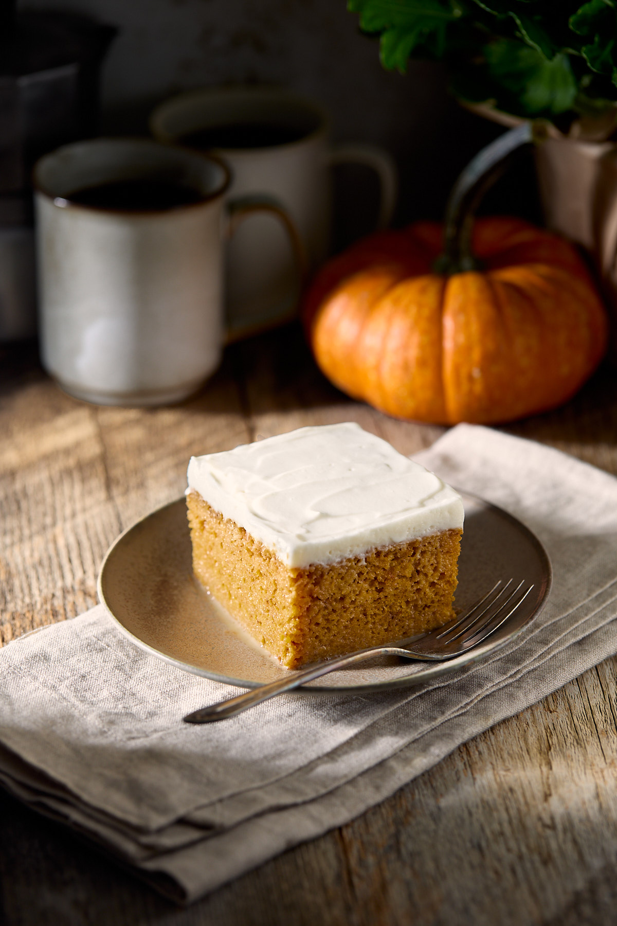 A slice of pumpkin tres leches on a small brown plate.