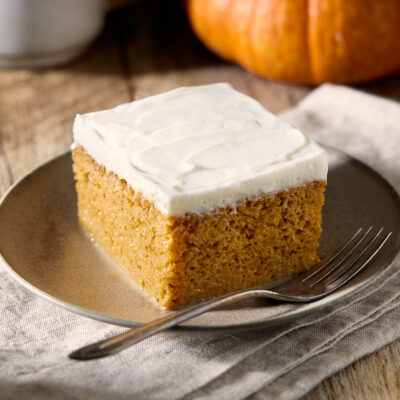 A slice of pumpkin tres leches on a small brown plate.